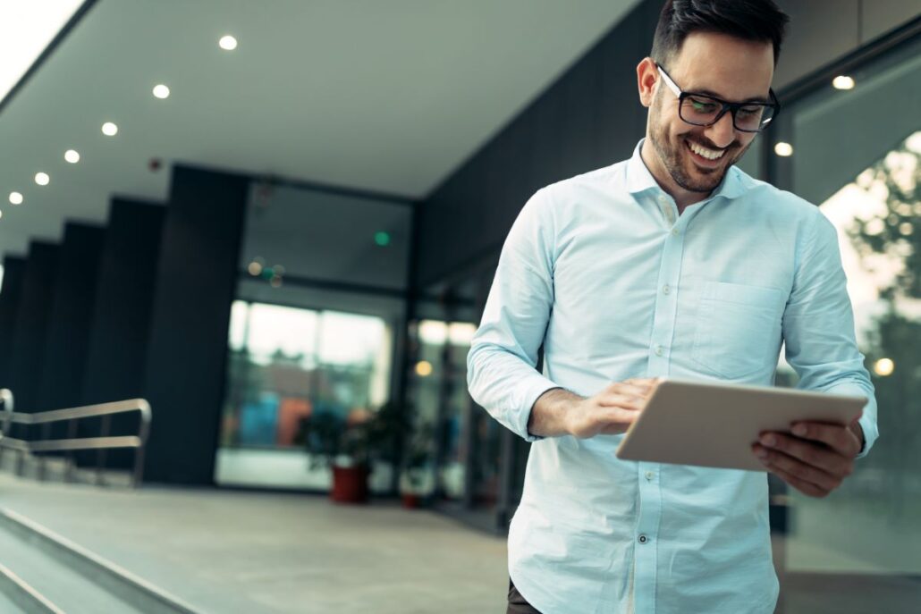 Empresário feliz e confiante usando tablet